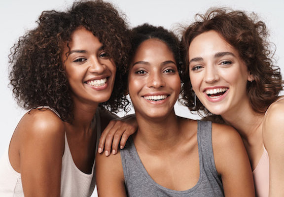 Portrait of young multiracial women standing together and smiling