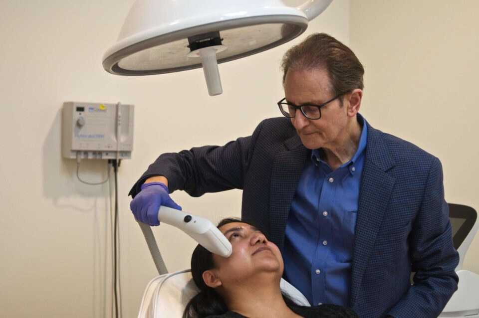 Dr. Greene performing Sofwave treatment on patient